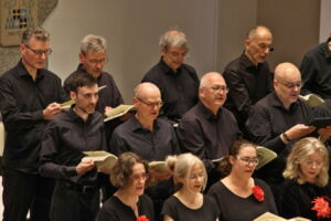 performs indoors, holding sheet music.