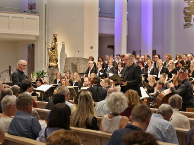 A choir and soloists perform in a church filled with an attentive audience.