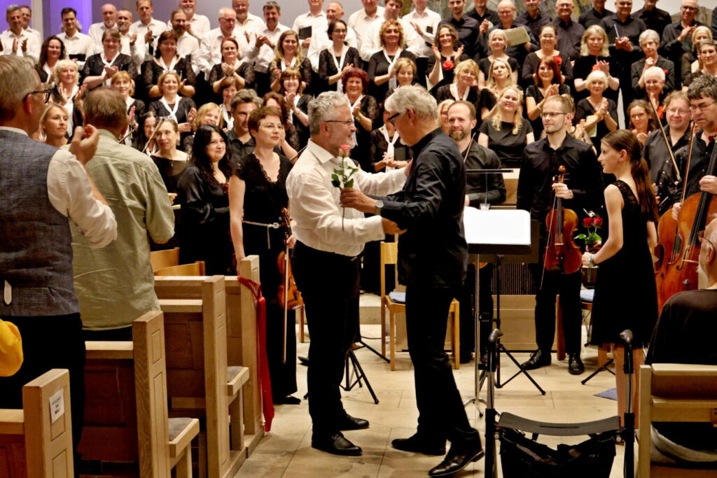A conductor passionately directs a musical performance in front of an attentive audience.